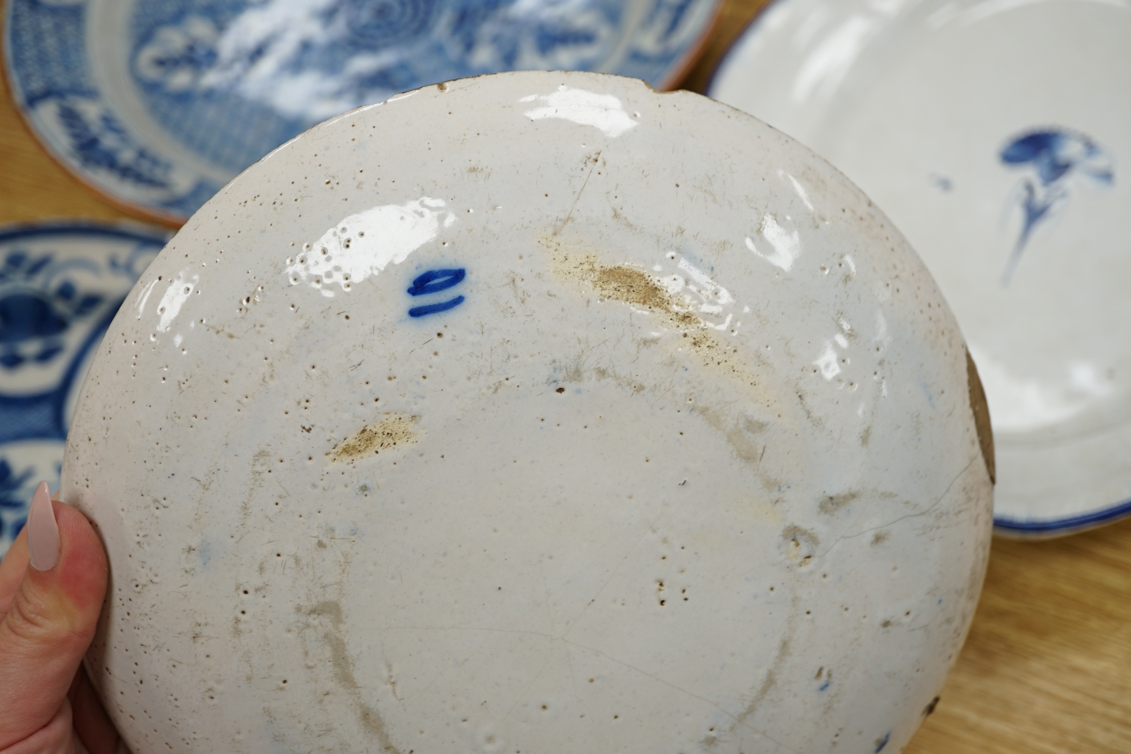 Four various continental delftware dishes, 18th and 19th century, largest 31cm diameter. Condition - various cracks and chipping to edges